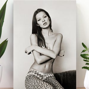 Può includere: Ritratto in bianco e nero di una donna con i capelli lunghi, le braccia incrociate e pantaloni fantasia. L'immagine è una stampa su tela, adatta per l'arredamento della parete. La fotografia è stata scattata in studio.