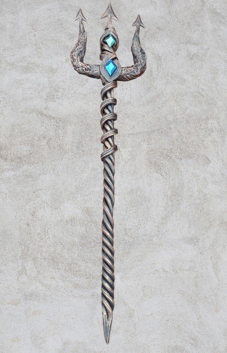 May include: A silver trident with a twisted handle and two blue gemstones. The trident is on a gray background.