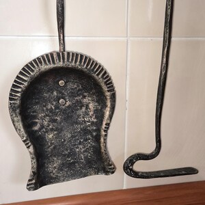 Peut inclure: Un ensemble d'outils de chemin&eacute;e, comprenant une pelle et un tisonnier, en m&eacute;tal fonc&eacute; avec une finition vieillie. La pelle a une cuill&egrave;re arrondie avec un bord d&eacute;coratif. Le tisonnier a une extr&eacute;mit&eacute; incurv&eacute;e.