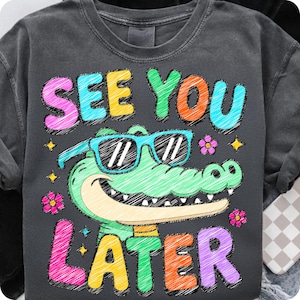 May include: Dark gray sweatshirt with a colorful graphic of an alligator wearing sunglasses. The text "SEE YOU LATER" is above and below the alligator. The design includes flowers and stars.