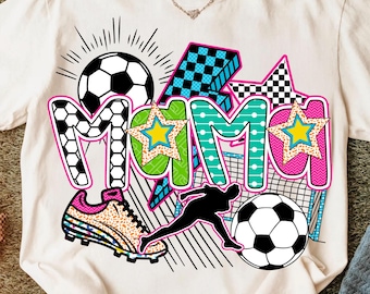 Puede incluir: Una camiseta blanca con un diseño gráfico colorido que presenta la palabra "Mama" en una fuente audaz y juguetona. El diseño incluye balones de fútbol, estrellas y un jugador de fútbol.