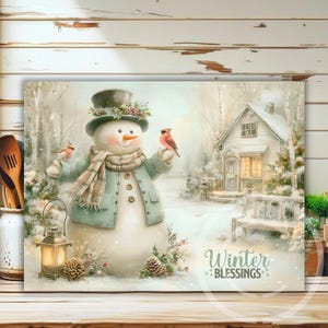 May include: A winter-themed canvas print featuring a snowman wearing a hat and scarf, holding a bird. A small house and the words "Winter Blessings" are also visible. The color palette includes soft blues, greens, and whites.