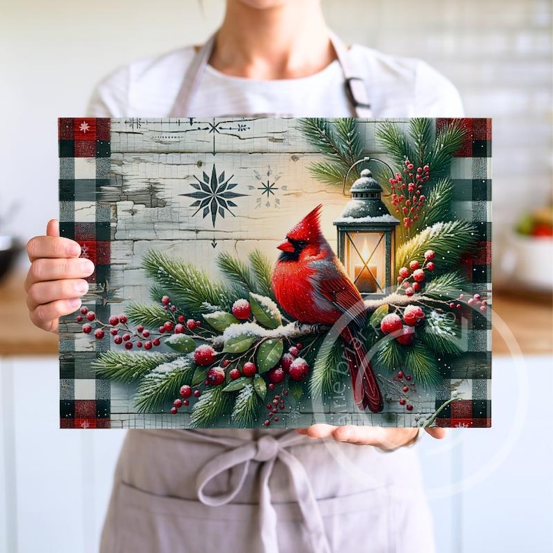 May include: A rectangular decorative piece featuring a vibrant red cardinal perched on a snow-covered branch with red berries and evergreen boughs. A lit lantern and snowflake designs are also present. The border has a black and red plaid pattern.