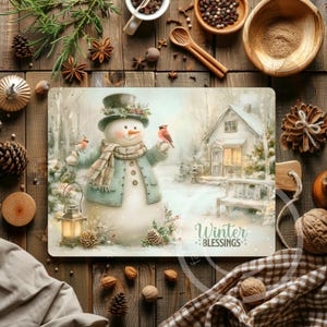 May include: A rectangular placemat featuring a snowman in a winter scene with a house and birds. The snowman wears a top hat, scarf, and coat. The placemat has the text "Winter Blessings" and is surrounded by wooden elements and seasonal decor.