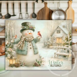 May include: A winter-themed print featuring a snowman wearing a hat and scarf, holding birds. A small house and the words "Winter Blessings" are also visible. The color palette includes soft blues, greens, and whites.