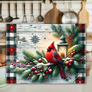 May include: A decorative rectangular wall art piece featuring a vibrant red cardinal perched on a snow-covered branch with red berries and evergreen boughs. A lantern with a lit candle sits nearby. The background is a rustic wooden panel with snowflake designs and a buffalo plaid border.