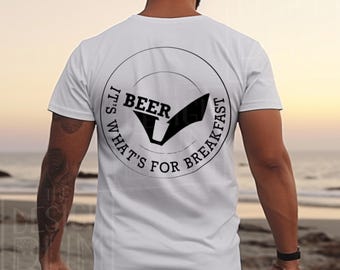 Op de afbeelding: Wit T-shirt met een zwarte afbeelding op de rug. De afbeelding is een cirkel met de woorden "IT'S WHAT'S FOR BREAKFAST" en "BEER" in het midden. Het shirt is een casual stijl.