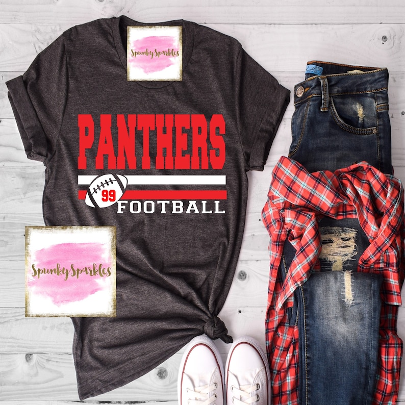 K&ouml;nnte beinhalten: Ein dunkelgraues T-Shirt mit den Worten "Panthers Football" in wei&szlig;er und roter Schrift. Das Shirt hat ein wei&szlig;-rotes Streifenmuster mit einer Fu&szlig;ballabbildung.