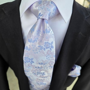 Conjunto de corbata, pañuelo de bolsillo y gemelos de seda con estampado floral azul claro y blanco.