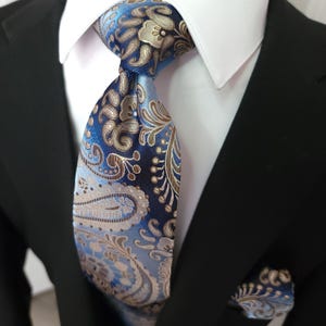 Set aus Krawatte, Einstecktuch und Manschettenknöpfen aus blau-champagnerfarbener Seide mit Paisley-Muster
