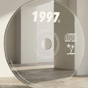 May include: Clear CD with the year "1997" in white, along with the text "COMPACT DISC DIGITAL AUDIO" and a palm tree graphic. The edge of the disc has the text "FOR ALL YOUSERS - Be mindful not to lose your own identity and values."