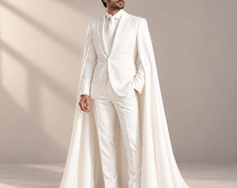 May include: A solid white suit featuring a single-breasted blazer with a notched lapel, a matching white dress shirt, a white necktie, slim-fit trousers, and a long, floor-length cape attached to the shoulders, paired with white boots.