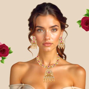 Könnte beinhalten: Ein goldfarbenes Schmuckset mit Halskette und passenden Ohrringen. Die Halskette und die Ohrringe sind mit roten Edelsteinen und kleinen weißen Perlen verziert. Das Set hat ein verziertes Design mit aufwendigen Details und einem Vintage-Look.