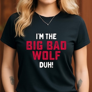 May include: Black t-shirt with the text "I'M THE BIG BAD WOLF DUH!" in white and red. The shirt has a crew neck and short sleeves. The text is in a bold, distressed font.