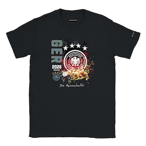 Könnte beinhalten: Schwarzes T-Shirt mit einem Grafikdesign für die deutsche Fußballnationalmannschaft. Das Design enthält den Text "GER" in Blau, das Jahr "2026" und die Worte "World Cup". Das Shirt zeigt auch das Emblem des Teams und den Satz "Die Mannschaft!"