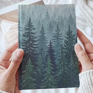 May include: A rectangular hardcover journal featuring a printed illustration of a dense forest with layered pine trees in varying shades of dark green, forest green, and muted sage, creating a deep, atmospheric woodland scene across the cover.