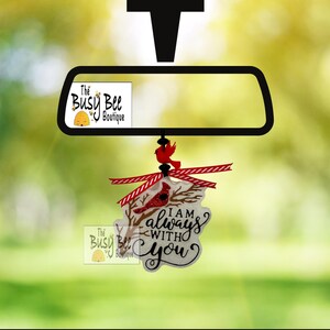 May include: A white car air freshener with a red cardinal and a white background. The text on the air freshener reads "I am always with you".