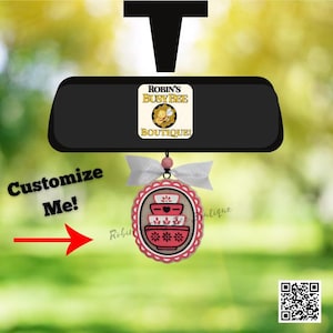 May include: An oval-shaped hanging ornament featuring a stack of three red and white bowls with floral and heart patterns. The ornament is topped with a white ribbon and a small pink bead. Text on the ornament reads ROBIN'S BUSY BEE BOUTIQUE.