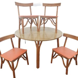 May include: A round dining table with four chairs. The table and chairs are made of light brown wood. The chairs have orange seat cushions. The table has a single central support. The chairs have curved backs and legs.