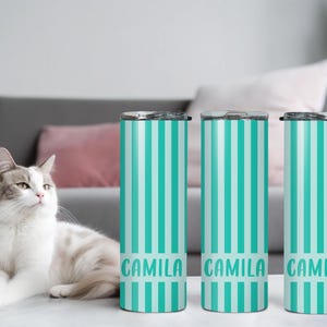 May include: Three tall, cylindrical stainless steel tumblers featuring a vertical striped pattern in alternating shades of teal and white. Each tumbler displays the name CAMILA printed in a bold, sans-serif font near the bottom base.