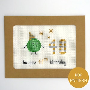 Może przedstawiać: Wyszywana kartka urodzinowa z zieloną postacią grochu w czapeczce i liczbą 40. Na kartce napis "ha-pea 40th birthday" czarnym tekstem. Karta jest w brązowej ramce z etykietą wzoru PDF.