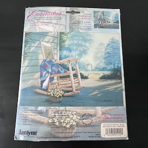 May include: A Janlynn counted cross stitch kit with a design of a rocking chair on a porch. The kit includes the design, instructions, and materials for a finished size of 40.6 x 31.8 cm. The text reads "Embellished".