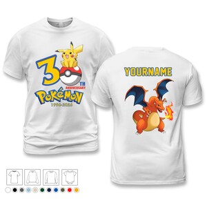 May include: White t-shirts with Pokémon designs. One features Pikachu on a Poké Ball with "30th Anniversary Pokémon 1996-2026". The other shows Charizard with "YOURNAME" text.