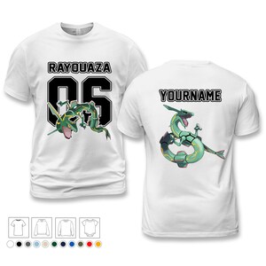 Puede incluir: Camisetas blancas con un gráfico de Rayquaza. Una camiseta presenta "RAYQUAZA 05" en la parte delantera, y la otra tiene "YOURNAME" en la parte posterior. Ambas camisetas muestran un diseño de Rayquaza verde y blanco.