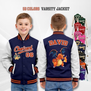 Può includere: Giacca college blu navy e bianca con dettagli arancioni. La parte anteriore presenta "Charizard" e "06" con un personaggio dei cartoni animati. Il retro mostra "DAVID" e una grafica di Charizard. Il testo "50 COLORS VARSITY JACKET" è in alto.