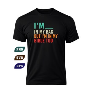 May include: Black t-shirt with the text "I'M IN MY BAG BUT I'M IN MY BIBLE TOO" in teal, orange, and white. The shirt also has the words "PNG", "SVG", and "EPS" in teal, brown, and blue.
