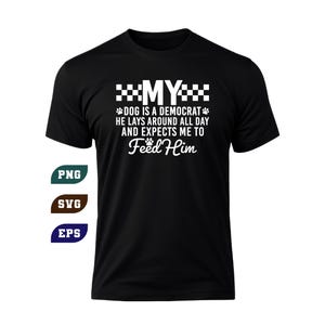 Op de afbeelding: Een zwart t-shirt met korte mouwen en witte tekst: MY DOG IS A DEMOCRAT HE LAYS AROUND ALL DAY AND EXPECTS ME TO Feed Him. Het ontwerp bevat kleine pootafdrukken en ruitpatronen. Drie kleine labels tonen de tekst PNG, SVG en EPS.