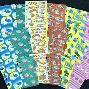 May include: A collection of colourful planner divider sheets featuring various patterns including blue rabbits on yellow ovals, green teapots, yellow strips with rocking horses and cherries, brown food illustrations, and yellow circus tents with blue accents.