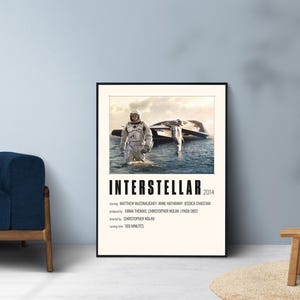 May include: A rectangular movie poster for Interstellar 2014 featuring a centered image of an astronaut in a white suit standing in water next to a spacecraft. The text includes the title, cast, production, director, and a runtime of 169 minutes.