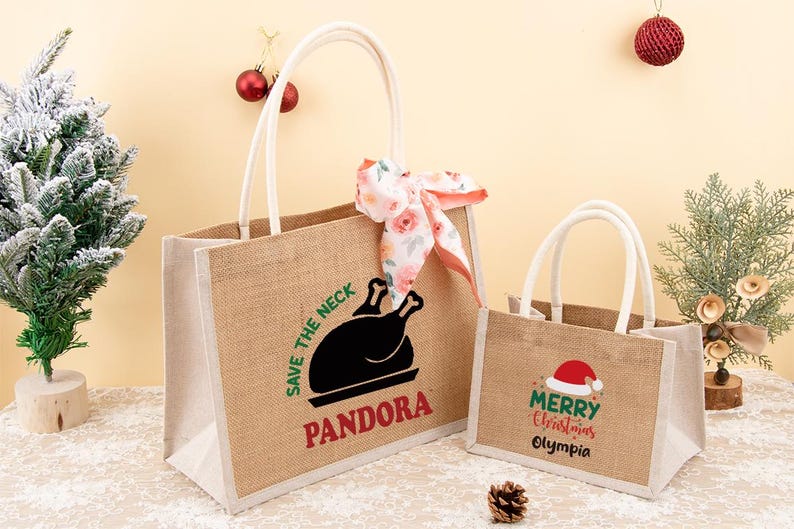 May include: Two jute tote bags with white handles. The larger bag has a black turkey graphic and the text "SAVE THE NECK" and "PANDORA". The smaller bag says "Merry Christmas Olympia" with a Santa hat.