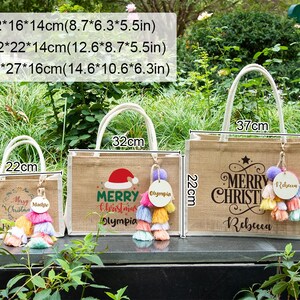 May include: Three burlap tote bags with white handles, each featuring a Christmas design and a tassel keychain. The largest bag is 14.6 inches wide, 10.6 inches tall, and 6.3 inches deep. The bags have the text "Merry Christmas" and names.