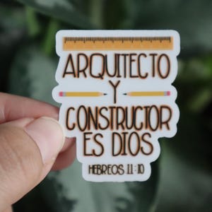 May include: White sticker with brown text that reads "Arquitecto y Constructor es Dios" with a yellow ruler and two pencils above the text. The text "Hebreos 11:10" is below the main text.