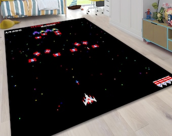 May include: A rectangular black rug featuring a pixelated space battle scene with a spaceship and enemy ships. The rug has a high score display and a retro video game aesthetic, perfect for a game room or bedroom.