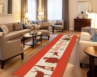 May include: A rectangular Christmas-themed rug with a red border and a cream-colored central panel. The panel features reindeer, Christmas trees, and the text "MERRY CHRISTMAS" in a festive design. The rug is placed in a living room.