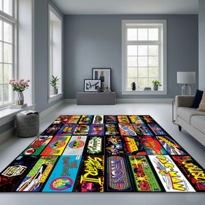May include: A rectangular area rug featuring a collage of colorful arcade game graphics. The rug showcases iconic game titles like Pac-Man, Street Fighter II, and Defender. The design is set against a black background, creating a vibrant and nostalgic aesthetic.