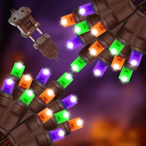May include: A string of LED lights featuring brown wire and alternating purple, orange, and green bulbs. The set includes a brown electrical plug and connector, with each bulb emitting a bright glow against a dark purple background.