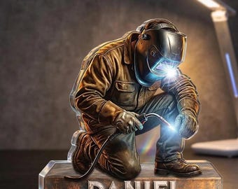 May include: A kneeling welder figurine with a welding torch, sparks, and the name "DANIEL" on the base. The welder wears a brown jacket, gloves, and a welding helmet. The base has a metallic, weathered appearance.