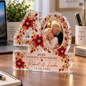 May include: A clear acrylic number 40-shaped plaque featuring red floral and gold leaf accents. It includes an oval photo of a couple, the text Ruby Wedding Anniversary, the names Robert & Linda, and the date 11.16.1986 printed on the front.