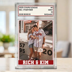 May include: A clear acrylic block featuring a photograph of a couple kissing, holding baseballs. The block includes text that reads "2025 COUPLE LEAGUE NO. 1 PARTNER" and "RICH & KIM". The block is labeled "#1 MINT 10".