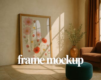 Pode incluir: Uma impressão de arte floral emoldurada com flores rosa e vermelhas, com o texto "frame mockup" em branco. A obra de arte é exibida em uma moldura de madeira clara, encostada em uma parede em um quarto bem iluminado.