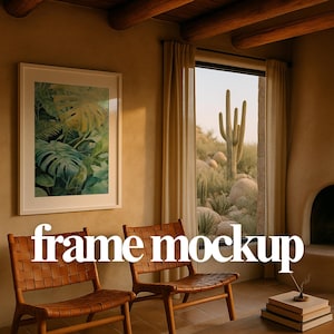 Op de afbeelding: Een interieur met een ingelijste botanische print, twee stoelen met geweven leer en een raam met uitzicht op een woestijnlandschap. De tekst "frame mockup" staat in witte letters.