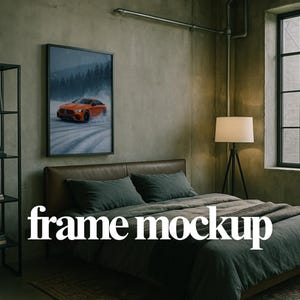 May include: A framed art print featuring an orange sports car speeding on a snowy road. The artwork is displayed above a bed with gray bedding. The words "frame mockup" are displayed in white.