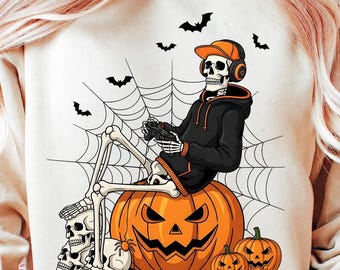Op de afbeelding: Een crèmekleurige Halloween-trui met een skelet met een hoed en koptelefoon, die een gamecontroller vasthoudt terwijl hij op een uitgesneden pompoen zit. Extra pompoenen, spinnen, vleermuizen en een spinnenweb maken het ontwerp compleet.