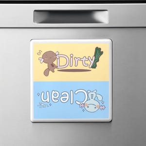 May include: A white magnetic sign with two sections. The top section is yellow with a brown axolotl holding a green leaf and the word "Dirty". The bottom section is blue with a light blue axolotl holding a sparkly star and the word "Clean".