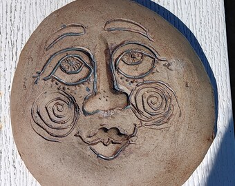 Lady face full moon with swirls 10 inches across fired to stoneware in joplin,mo for indoor or outdoor  will not freeze and break