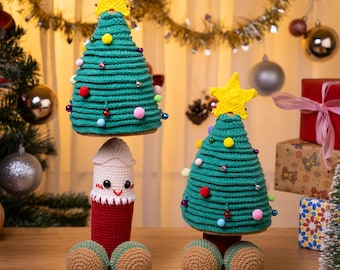 May include: Handmade Christmas tree ornaments. The ornaments are green, with colorful pom-poms and a yellow star on top. The ornaments are crocheted and have a whimsical design. The ornaments are on a wooden surface.